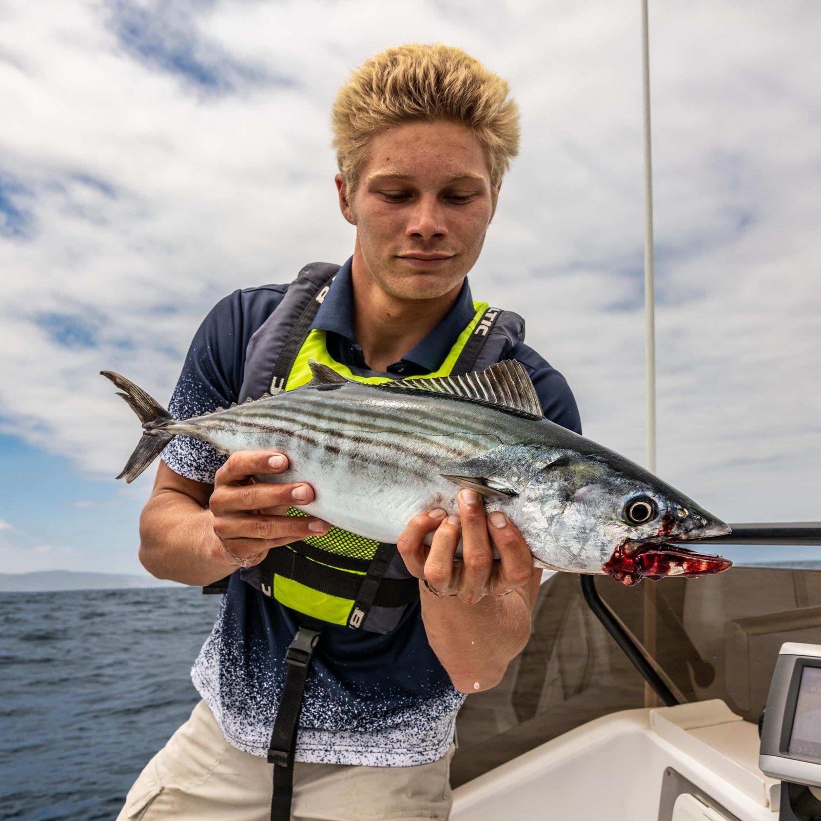 Angler showing a catch from a Knysna Lagoon fishing trip